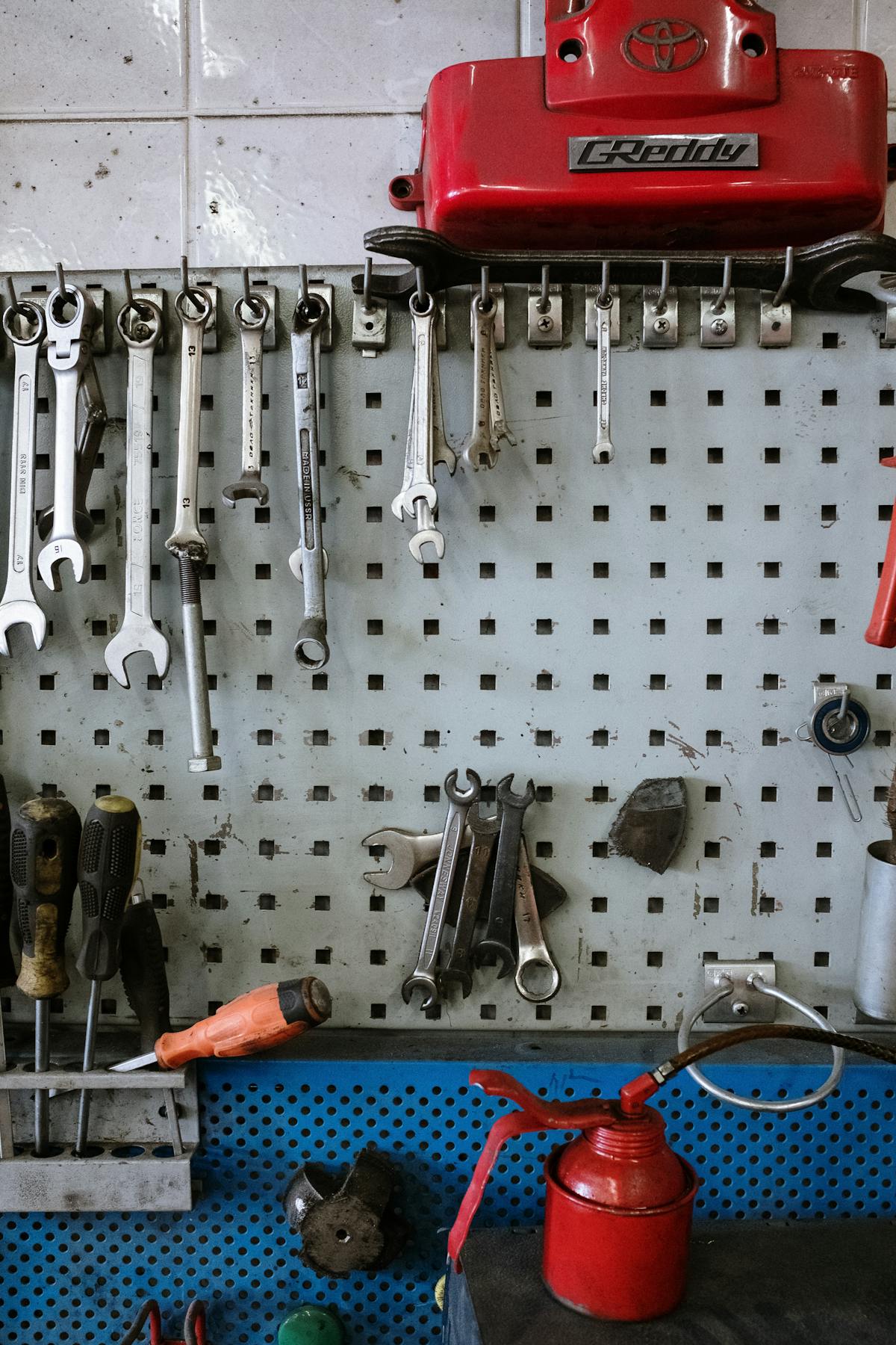A neatly organized set of mechanic's tools on a workshop pegboard.